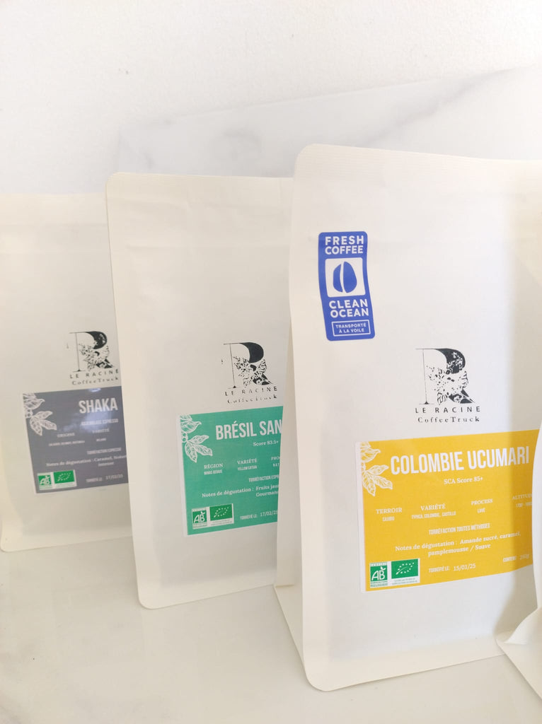 Three bags specialty artisanal organic roasted coffee. White kraft Le Racine Coffee